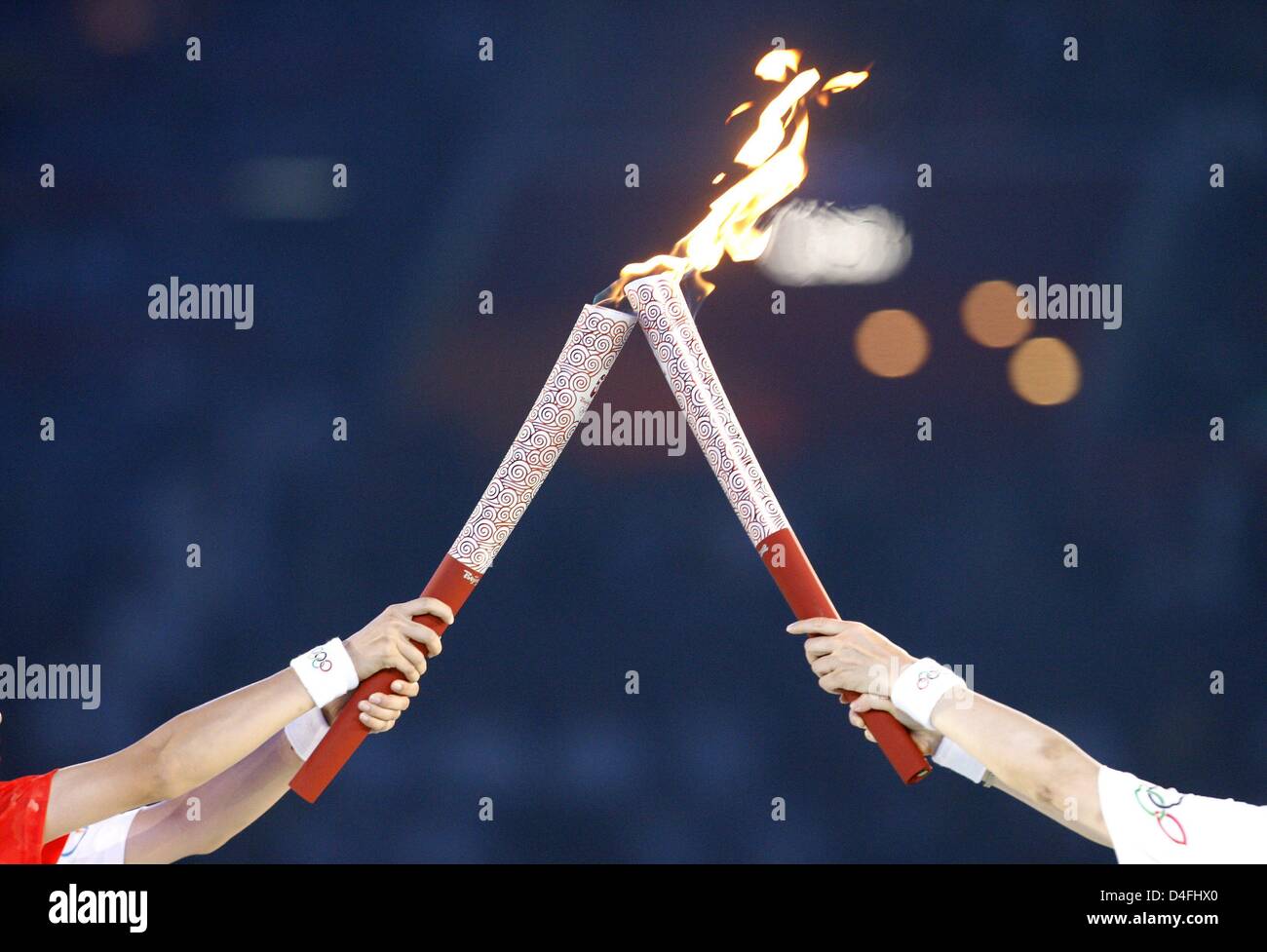 Torch bearers hand-over the flame during the Opening Ceremony of the Beijing 2008 Olympic Games at the National Stadium, known as Bird's Nest, Beijing, China, 08 August 2008. Foto: MARCUS BRANDT (c) dpa - Bildfunk Stock Photo