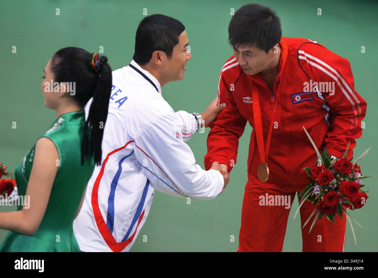Silver medal winner Jong Oh Jin (C) from South Korea congratulates bronze medallist Jong Su Kim (R) from North Korea during the medal ceremony in the men`s 10m air pistol qualification in the Beijing Shooting Range Hall at the Beijing 2008 Olympic Games, Beijing, China, 09 August 2008. Photo: Jens Buettner dpa (c) dpa - Bildfunk Stock Photo