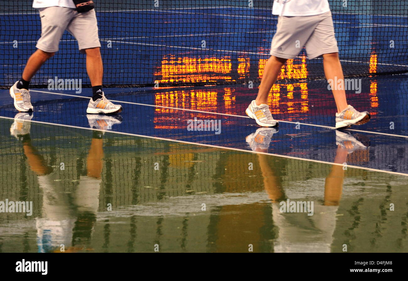 Volunteers are reflected in the water tennis court at the Olympic Green Tennis Center during a rain delay during the Beijing 2008 Olympic Games at the National Aquatics Center in Beijing, China 10 August 2008. The 1st round match mens single tennis match of Nicolas Kiefer from Germany and Max Mirnyi from Belarus is unhold because of heavy rain. Photo: Karl-Josef Hildenbrand dpa ### Stock Photo