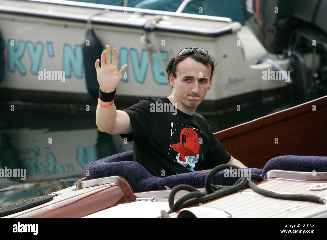 Polish Formula One driver Robert Kubica of BMW Sauber waves from a boat