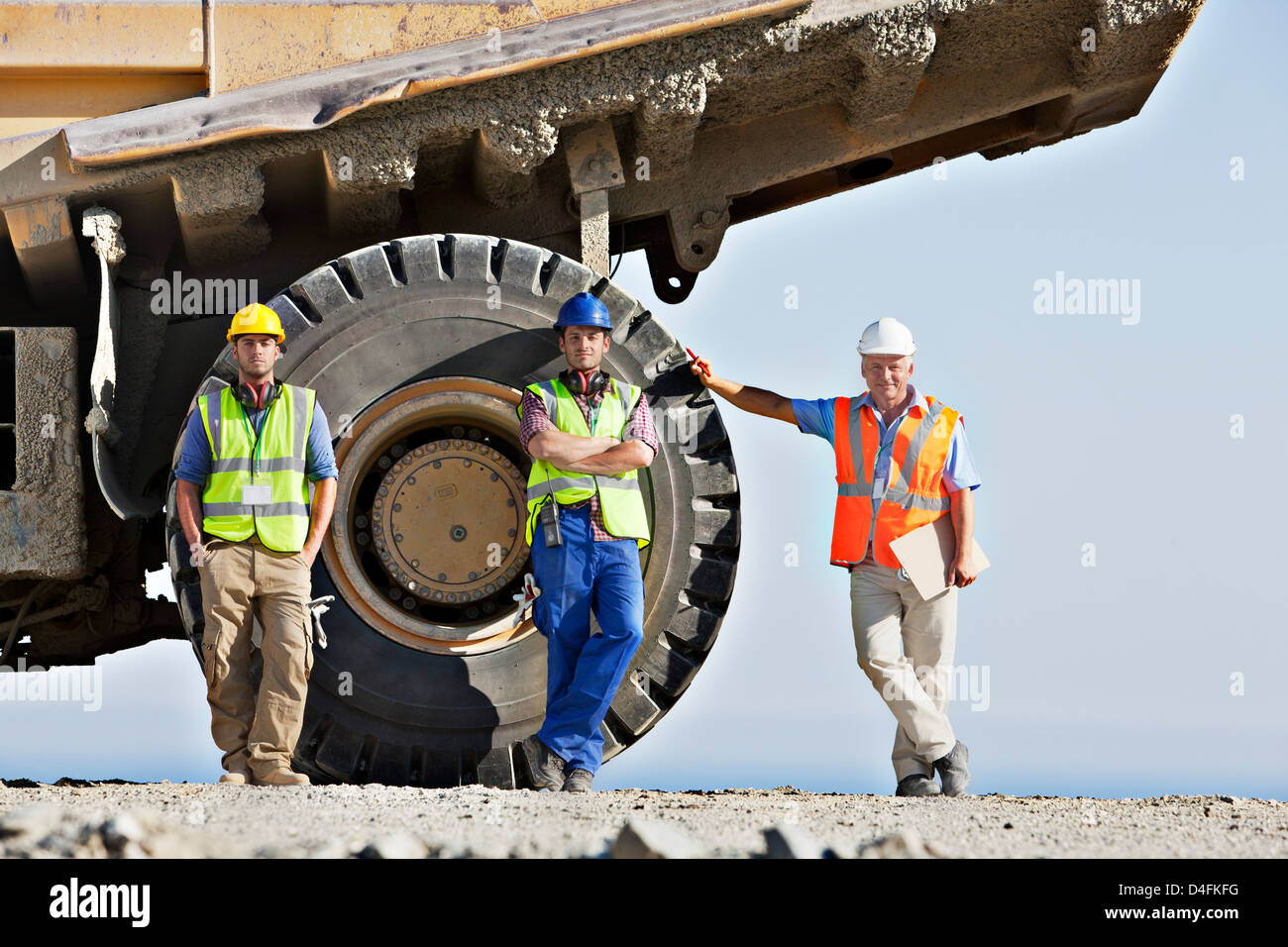 Workers standing by machinery on site Stock Photo