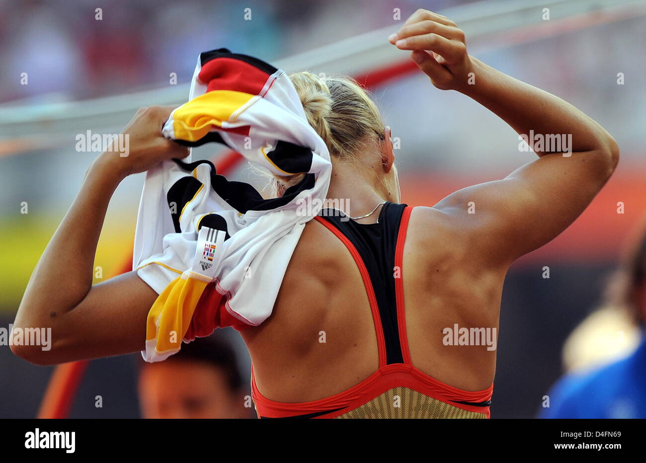 German Jennifer Oeser takes off her shirt in the women's heptathlon high jump of the Athletics events in the National Stadium at the Beijing 2008 Olympic Games, Beijing, China, 15 August 2008. Photo: Karl-Josef Hildenbrand dpa ###dpa### Stock Photo