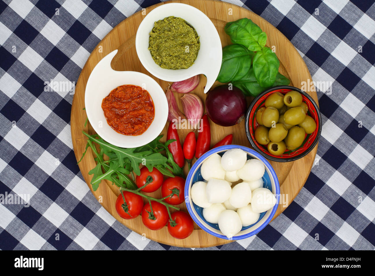 Italian ingredients on wooden board on checkered tablecloth Stock Photo