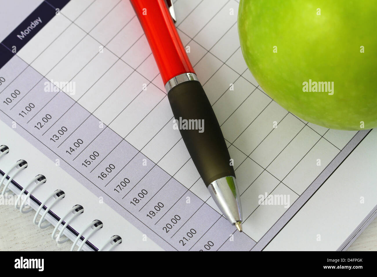 Open empty agenda, pen and green apple Stock Photo