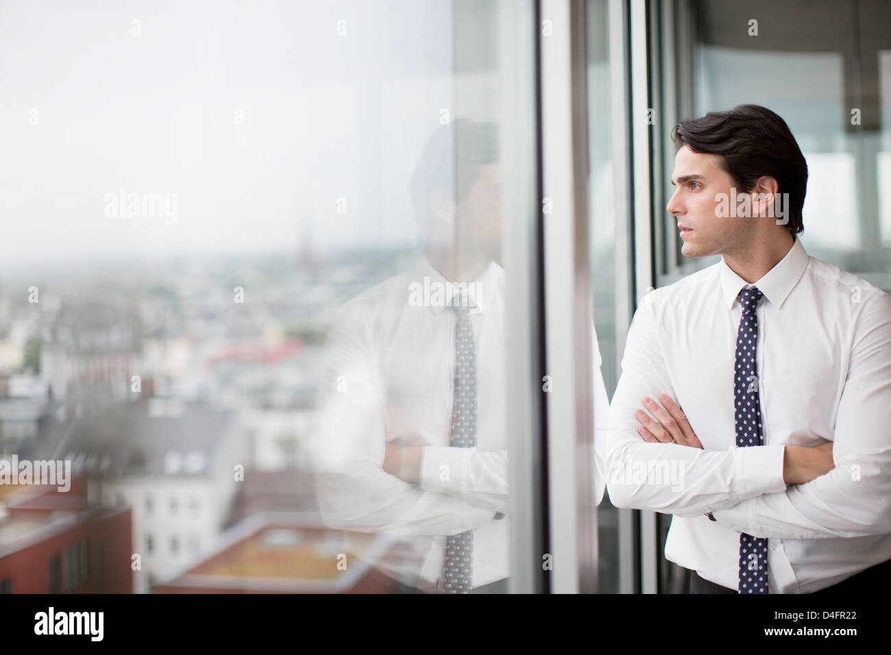 Businessman looking out office window Stock Photo Alamy
