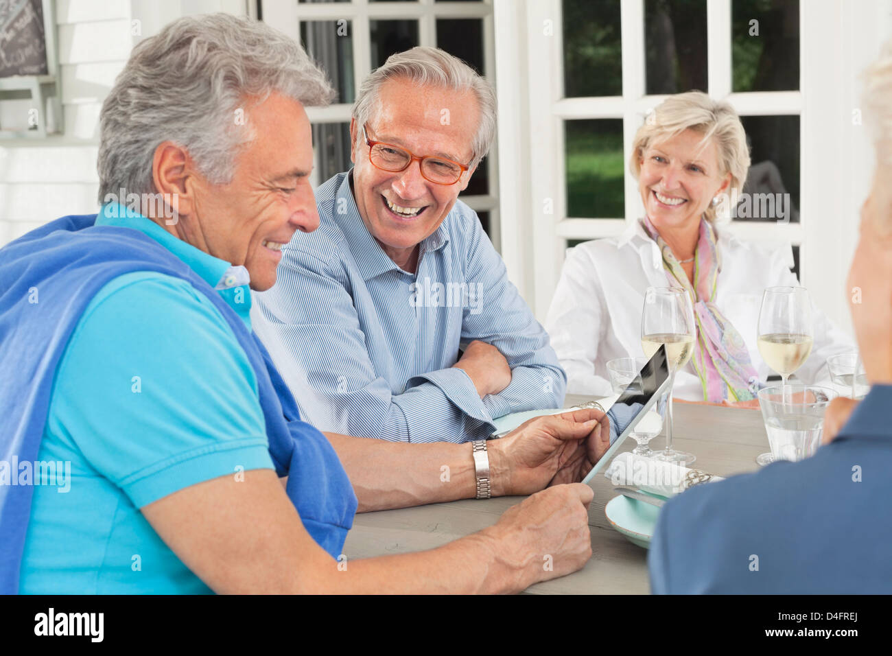 Friends using digital tablet together Stock Photo