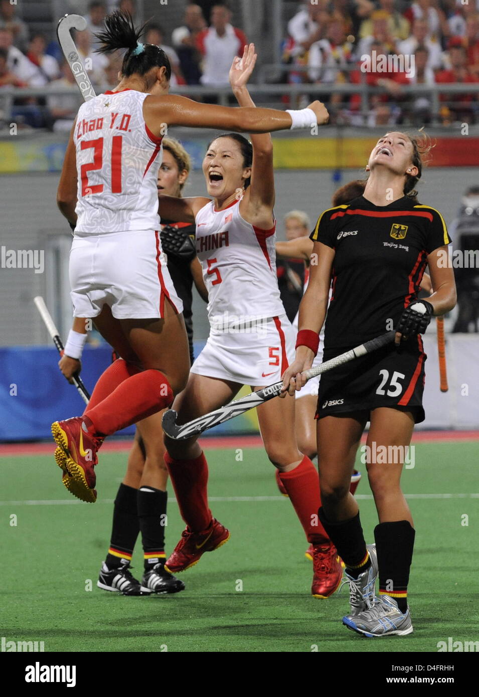 Janne Mueller-Wieland (R) from Germany looks dejected while Yudiao Zhao (C) from China is celebrated by teammate Hui Cheng after she has scored the 3:2 winning goal during the Semifinal match Germany against China in the womenÒs Field Hockey competition at the Beijing 2008 Olympic Games, Beijing, China, 20 August 2008. Photo: Peer Grimm dpa ###dpa### Stock Photo