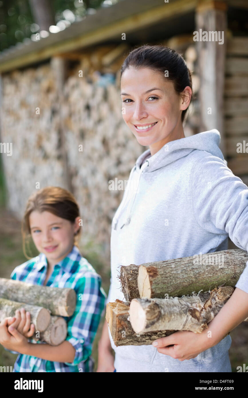 Mother and daughter carrying firewood outdoors Stock Photo - Alamy