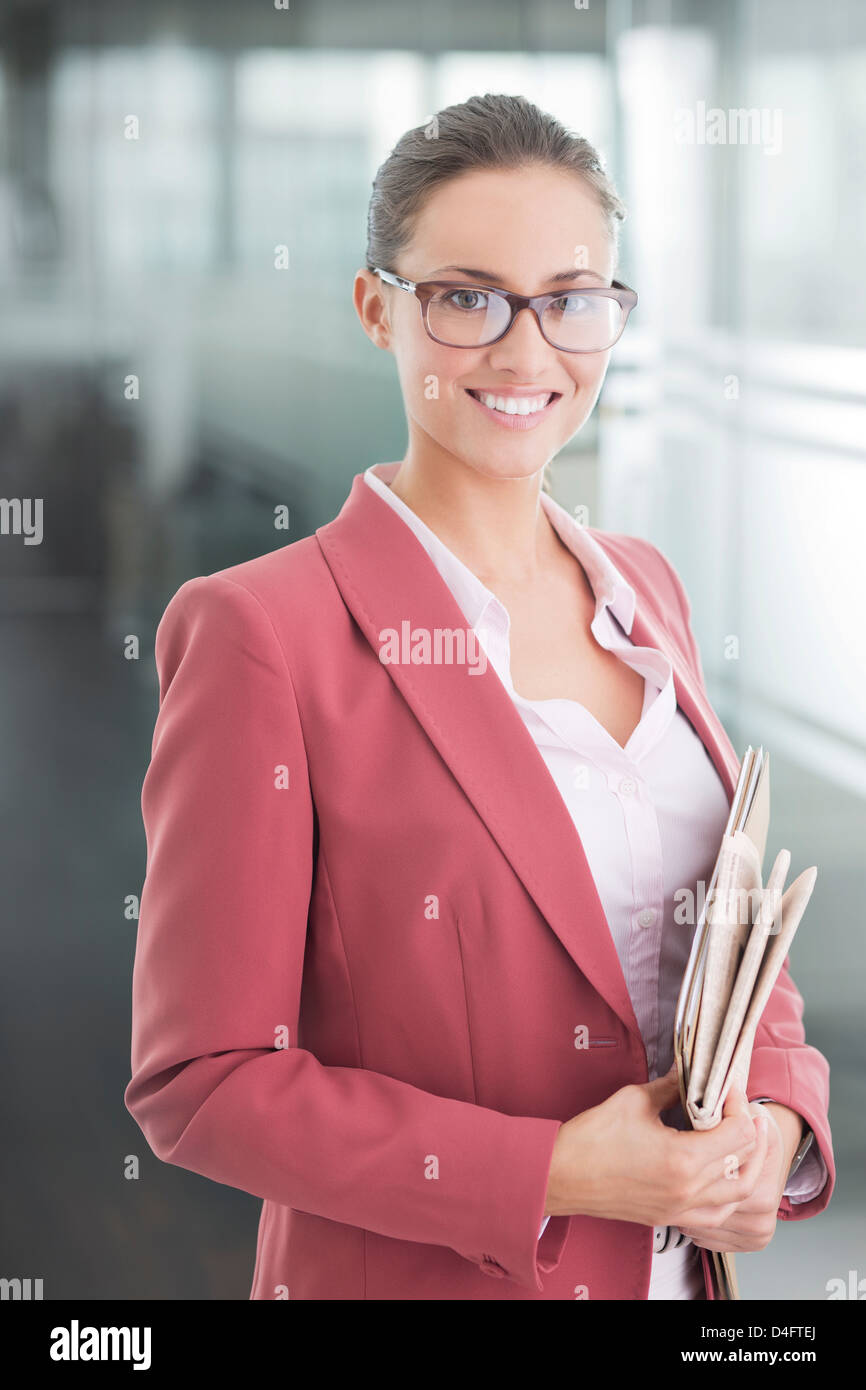 Businesswoman standing in office hallway Stock Photo