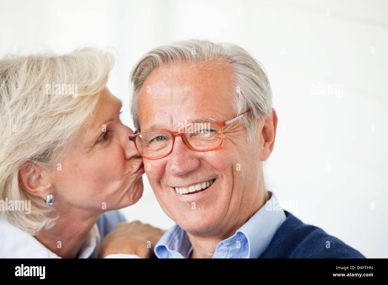 Smiling woman kissing husband Stock Photo