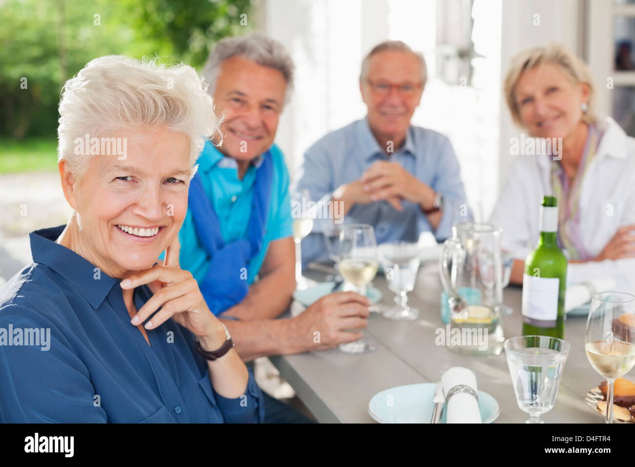 Friends smiling at table outdoors Stock Photo