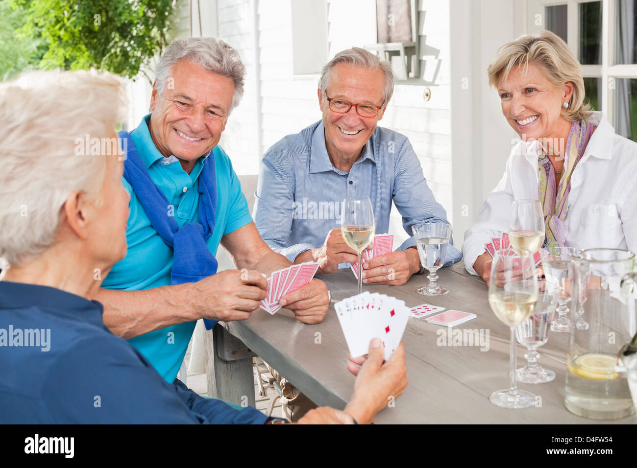 Friends playing card games at table Stock Photo