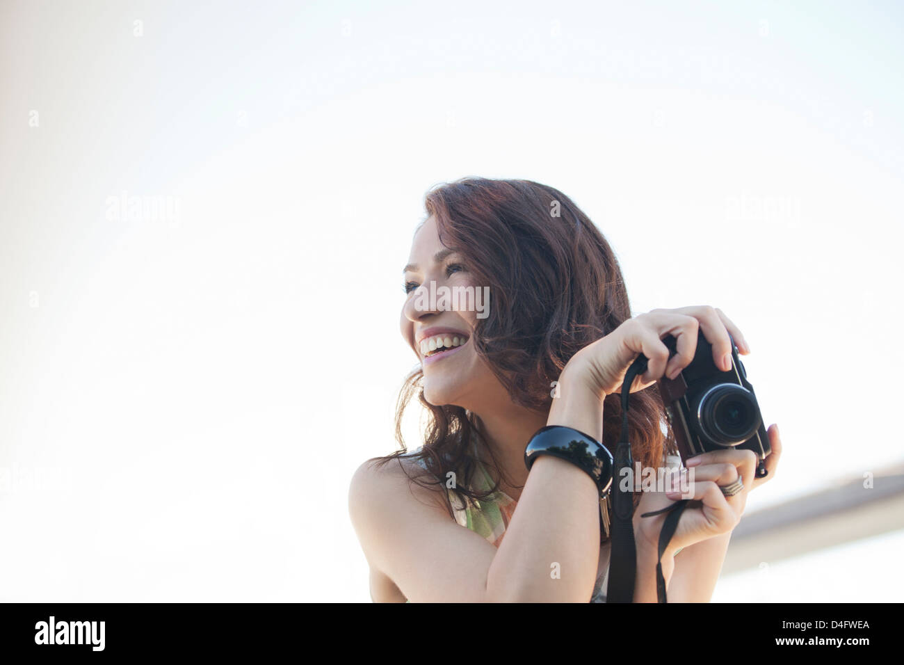 Smiling woman taking pictures outdoors Stock Photo
