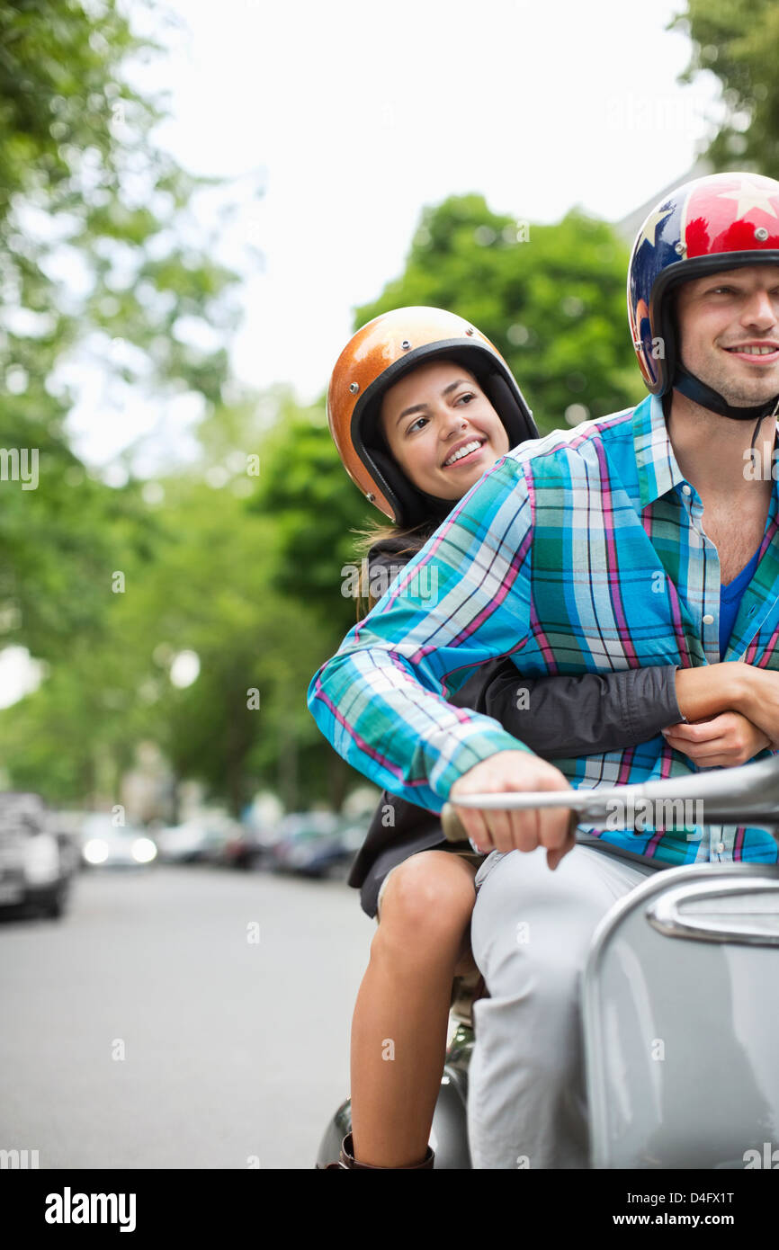 Couple riding scooter together Stock Photo