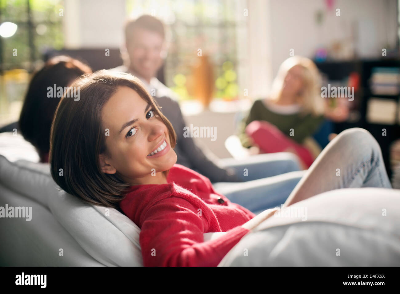 Smiling woman relaxing on sofa Stock Photo - Alamy