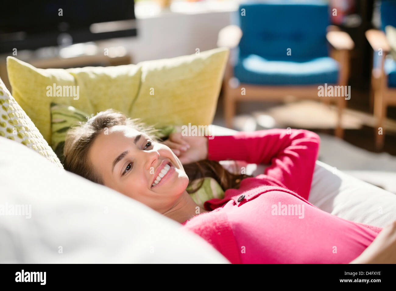 Smiling woman relaxing on sofa Stock Photo - Alamy