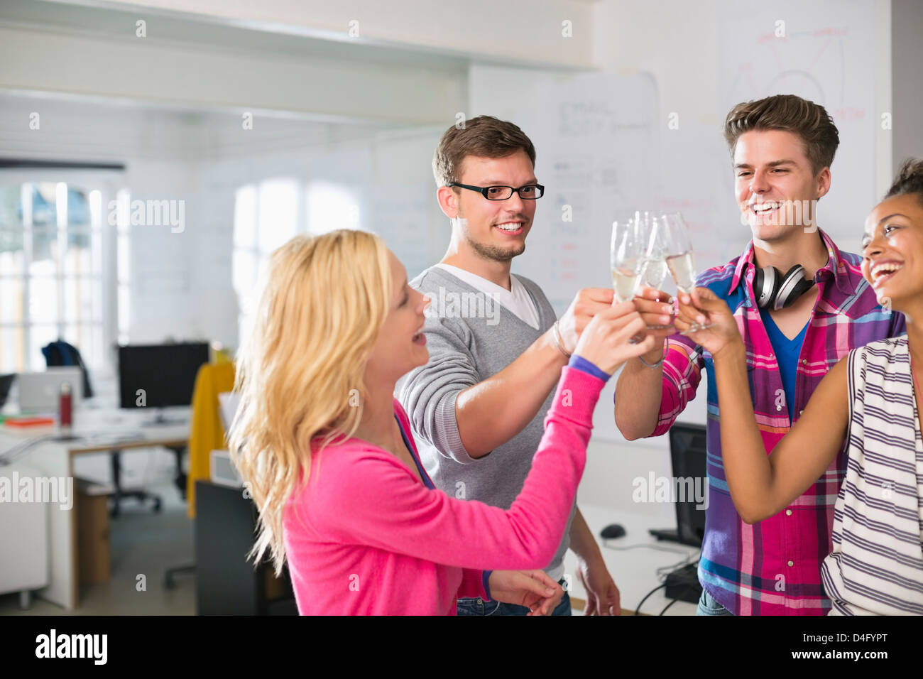 Business people toasting each other with champagne in office Stock Photo