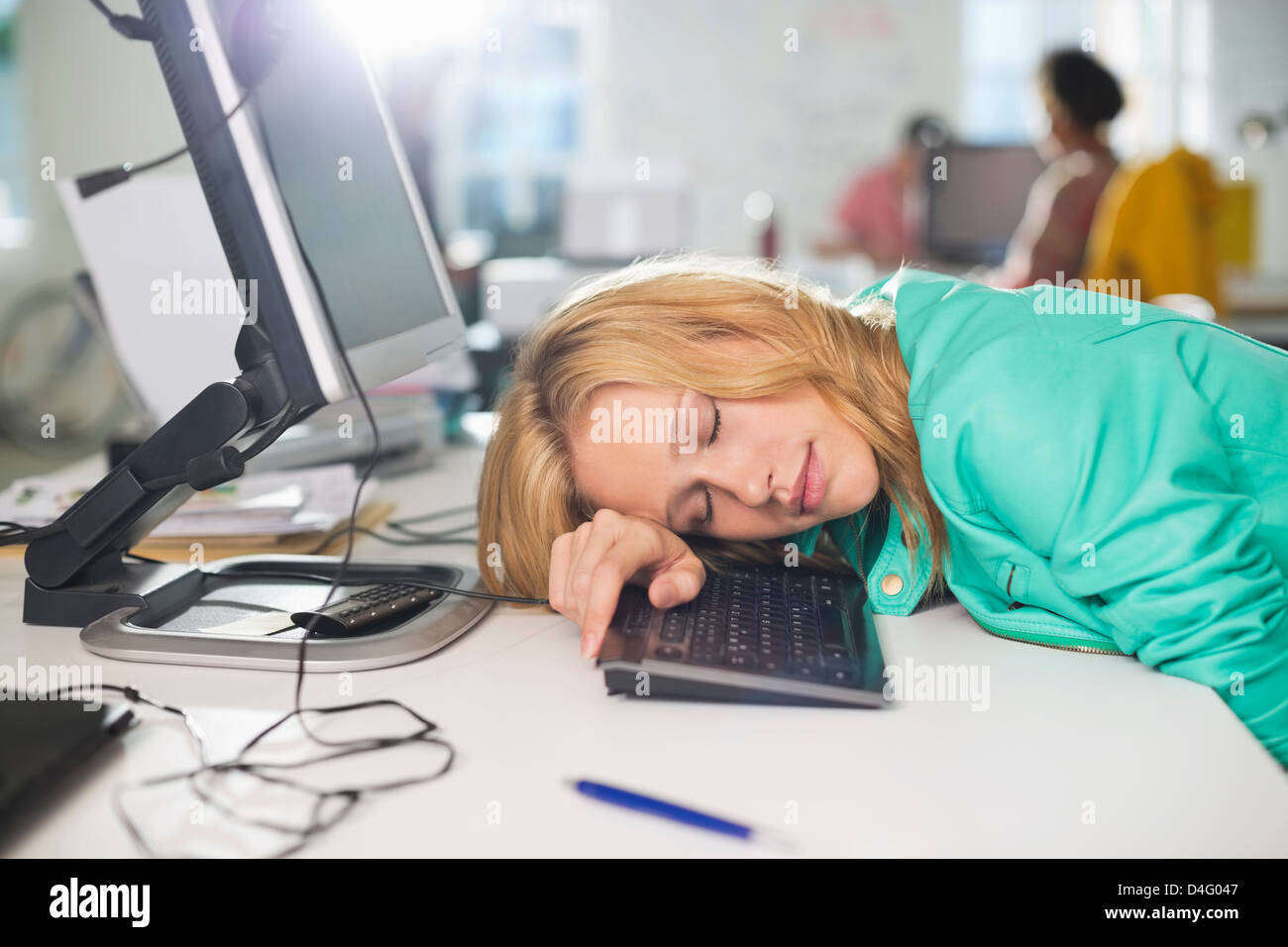 Businesswoman sleeping at desk Stock Photo