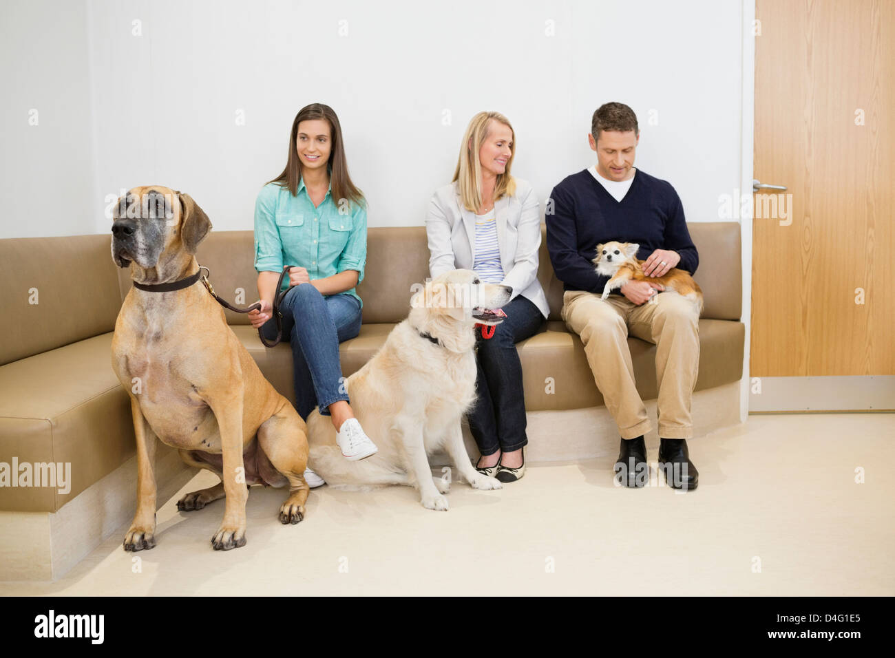 Owners with pet in waiting area†of vet's Stock Photo