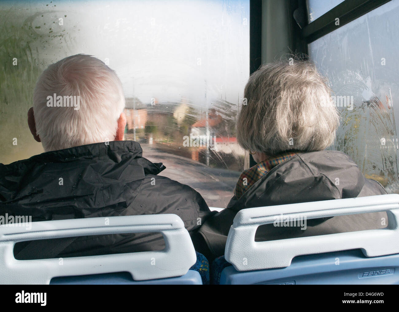 Retired couple riding on the upper deck of a double decker bus within north east England Stock Photo