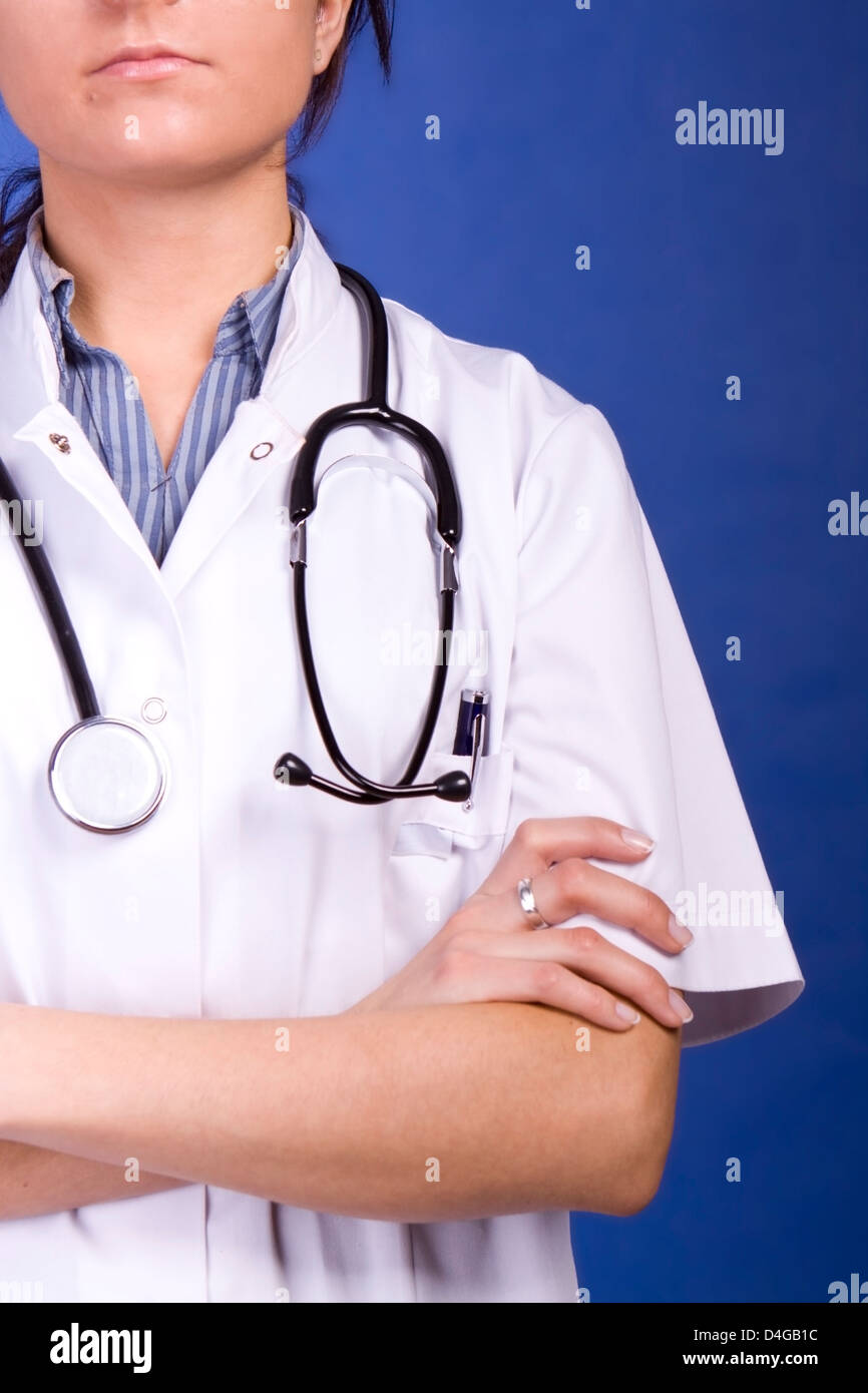 Women Doctor with arms crossed , tight cropping, unrecognizeable, graduated blue background Stock Photo
