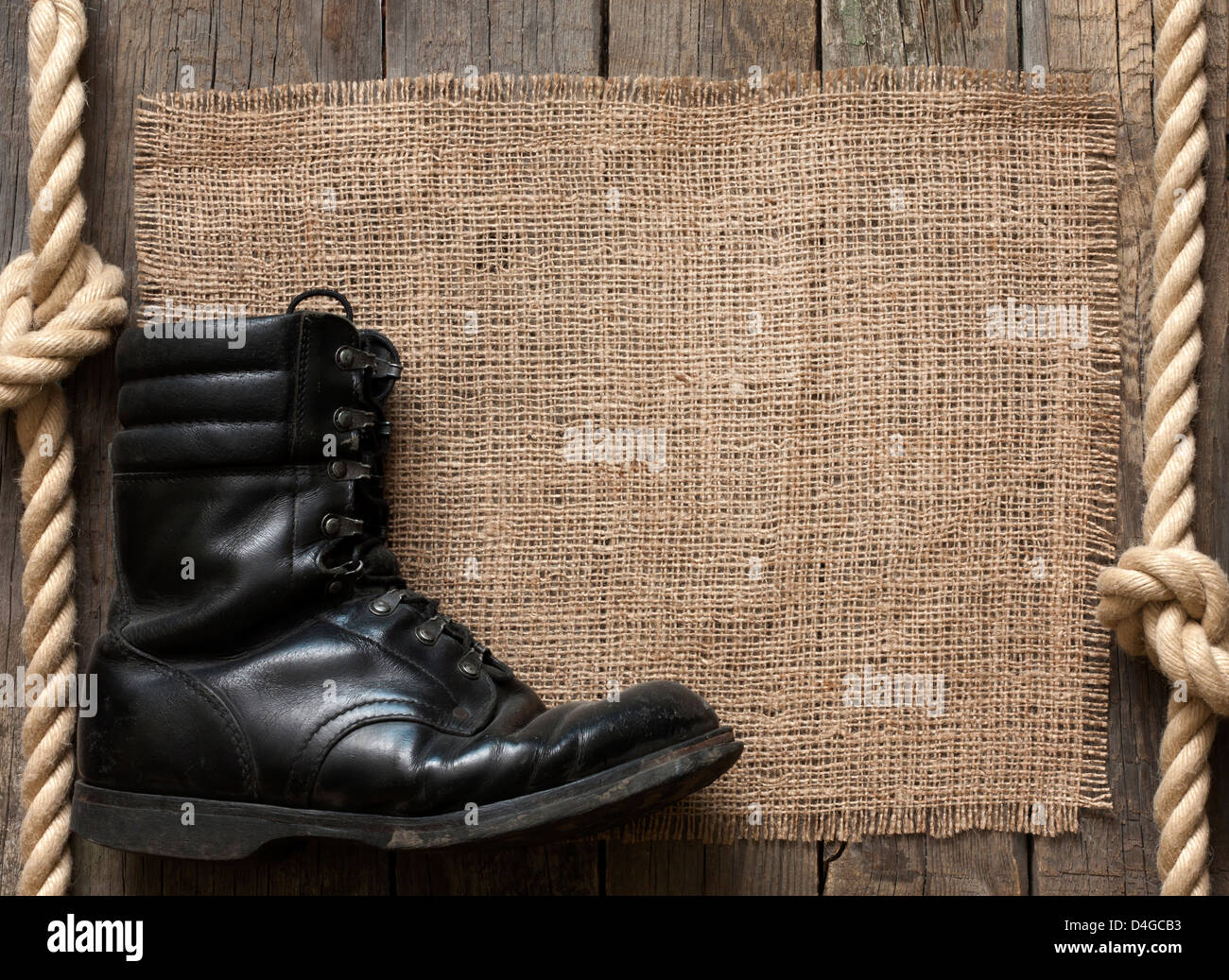 Old military shoes on wooden boards abstract background concept Stock Photo