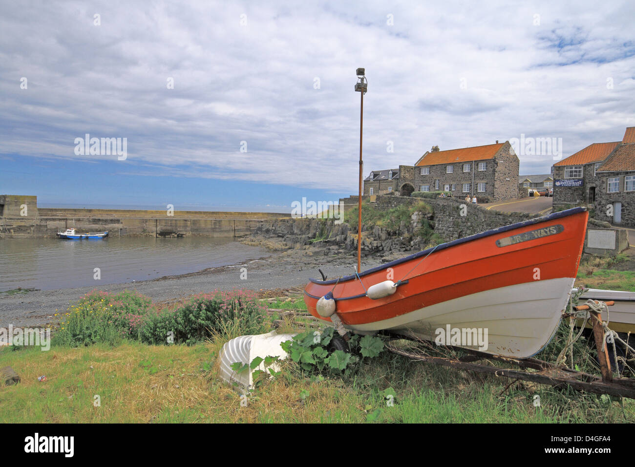Red & White Wooden Fishing Boat Moored Up at Craster Harbour, Northumberland, England, UK Stock Photo