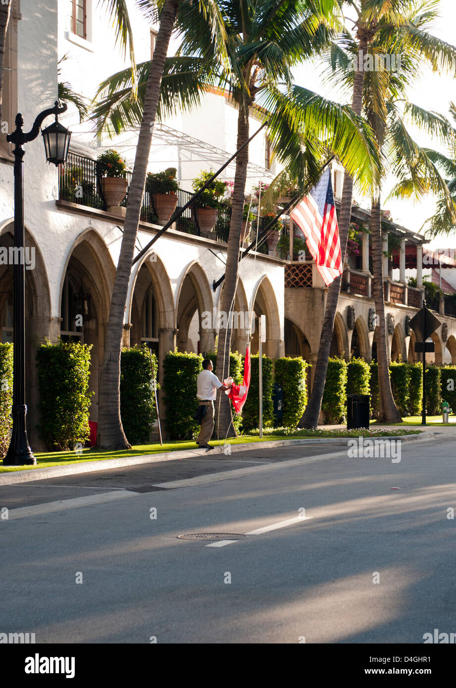 A man raising flags in the morning on Worth Avenue, West Palm Beach Florida Stock Photo