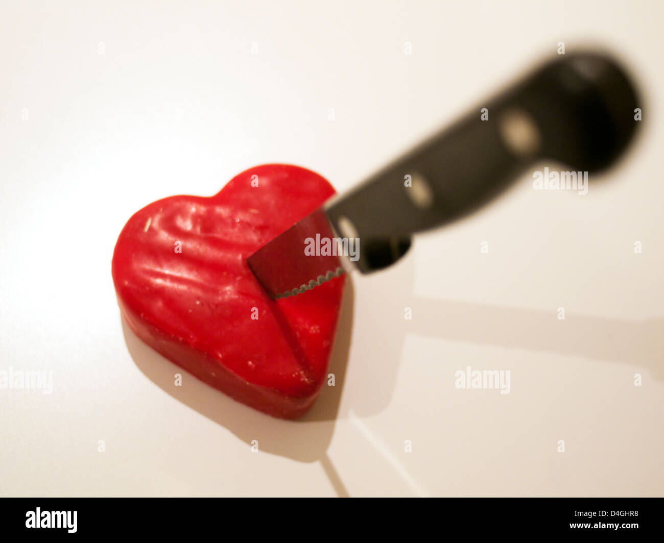 Knife in the heartshaped cheese Stock Photo Alamy