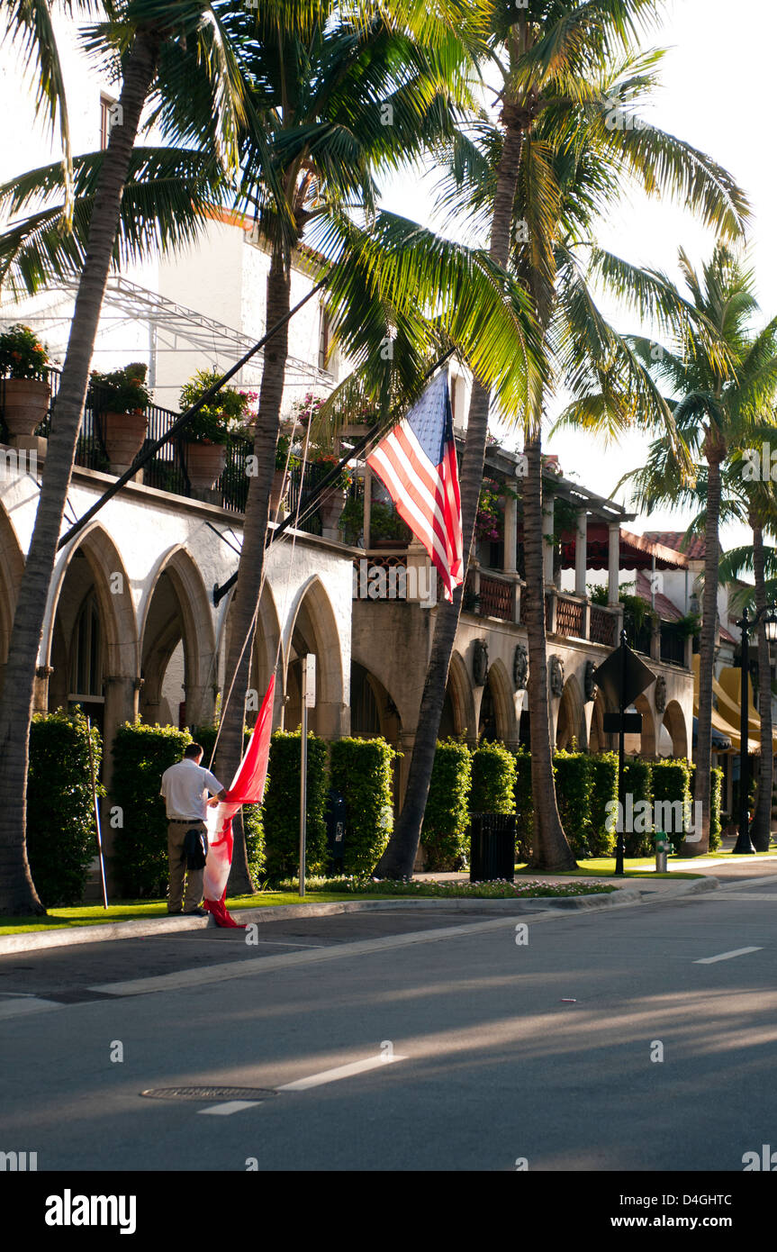 Man Raising flags in the morning on Worth Avenue, West Palm Beach Florida Stock Photo