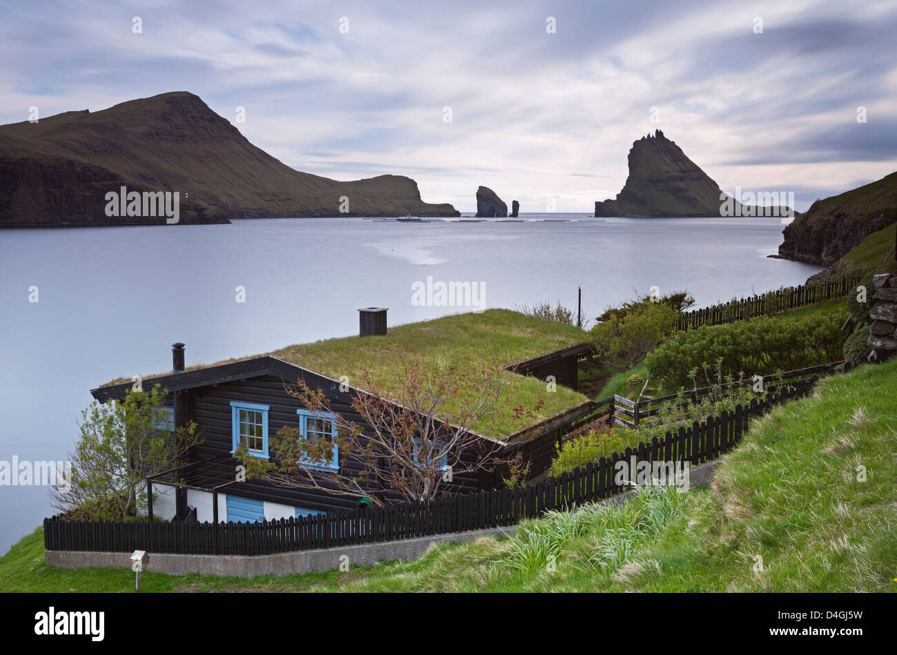 Traditional grass roofed house in the village of Bour, with views to Tindholmur, Vagar, Faroe Islands. Summer (June) 2012. Stock Photo