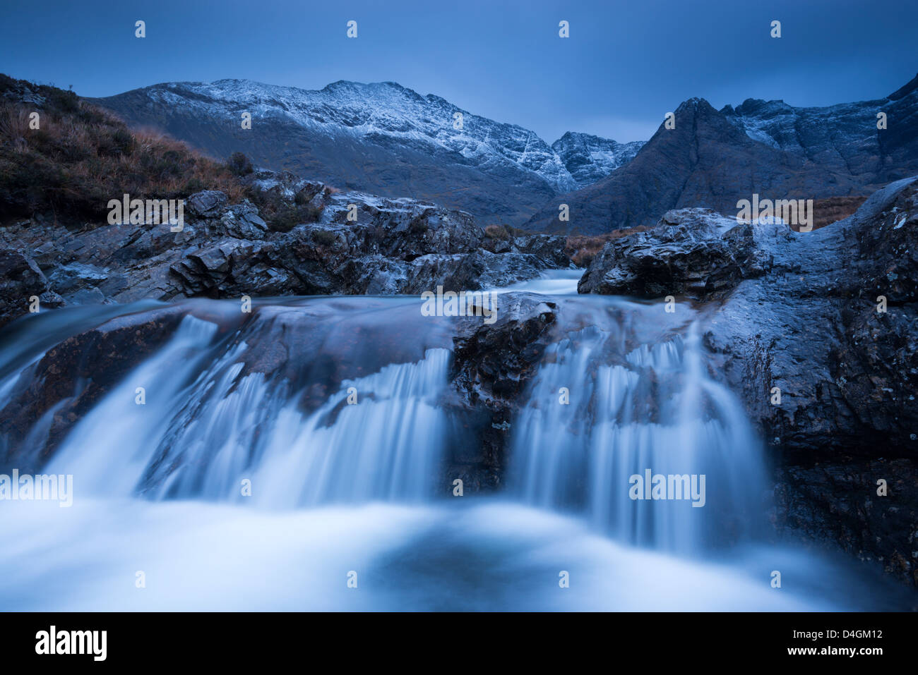 Fairy Pools waterfalls at Glen Brittle, with the snow dusted Cuillin mountains beyond, Isle of Skye, Scotland. Stock Photo