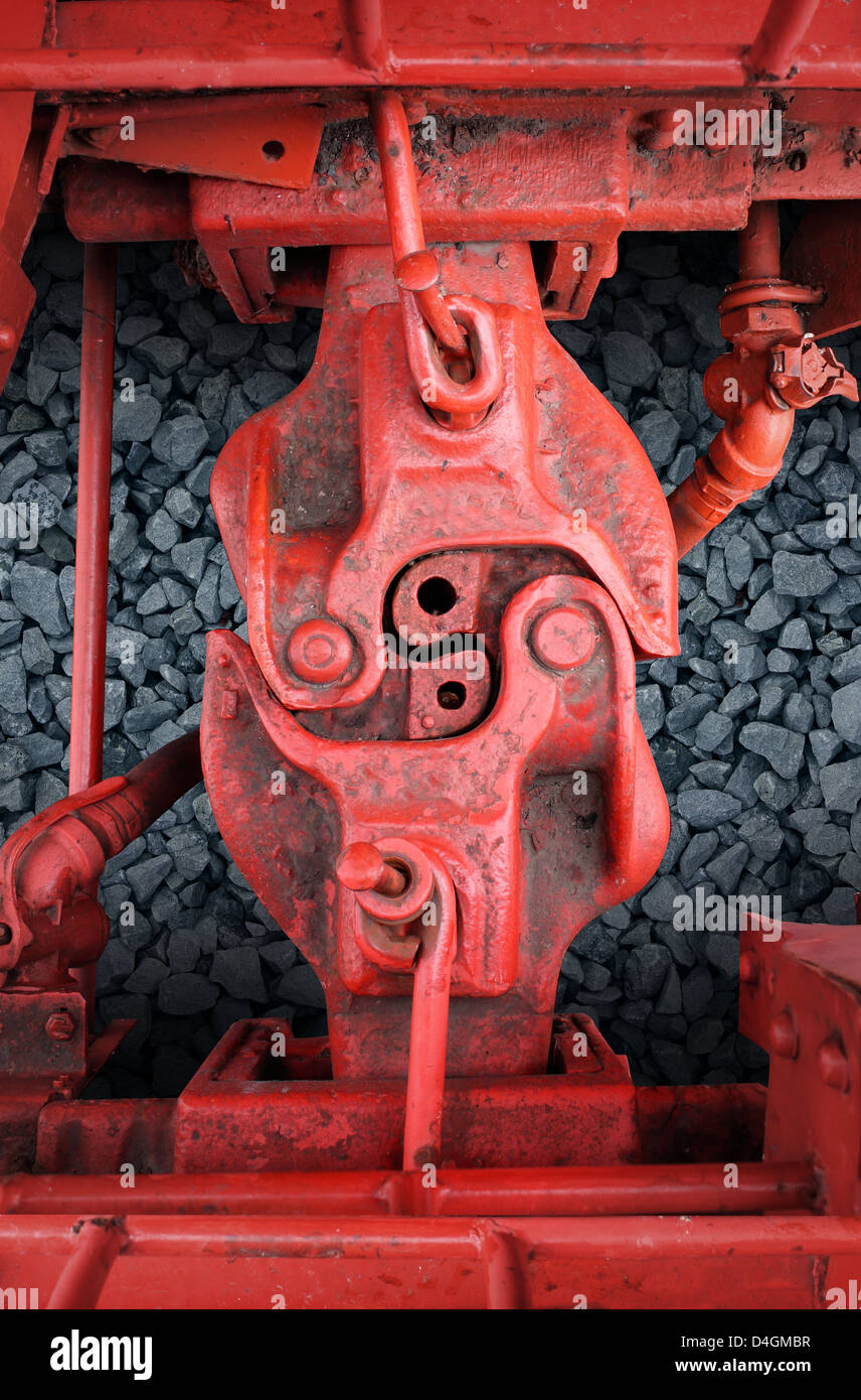 Strong connection with red train car metal coupling connected together as a business symbol of strength in partnership and an unbreakable agreement or contract between two team members. Stock Photo