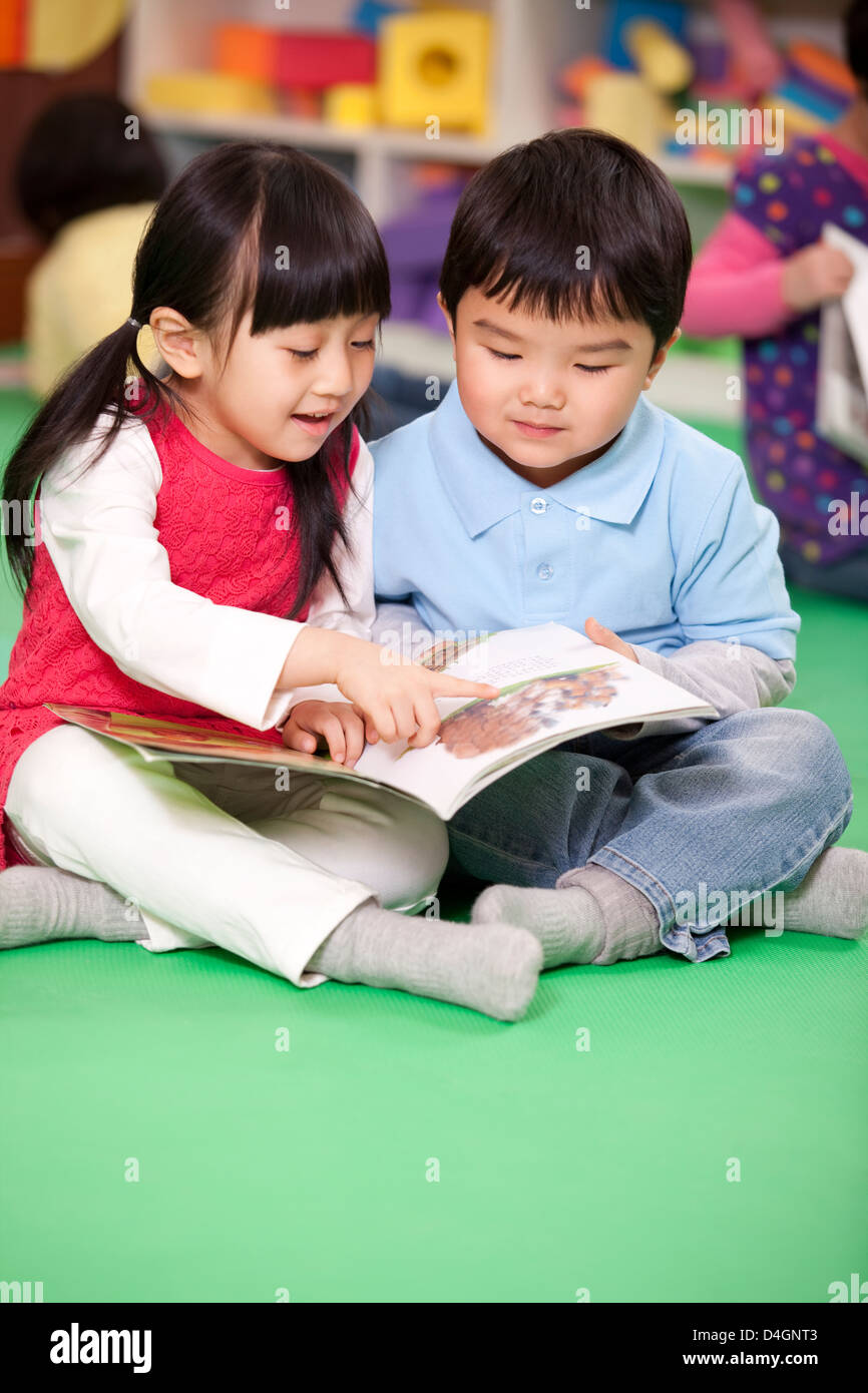 Cute little girl and little boy reading books Stock Photo - Alamy