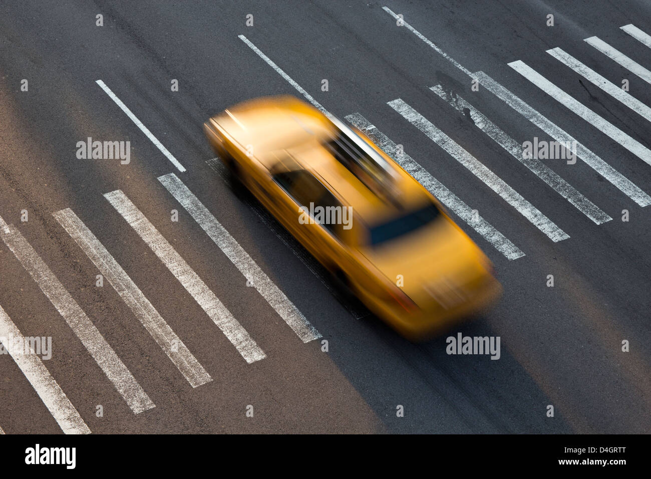 Yellow taxi of New York traversing a zebra crossing Stock Photo