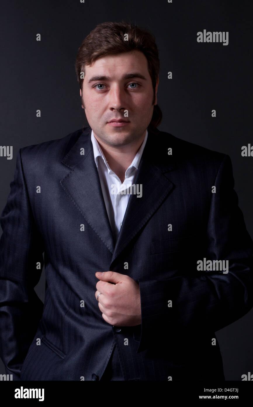 portrait of a young man in a black suit with a gray background Stock ...