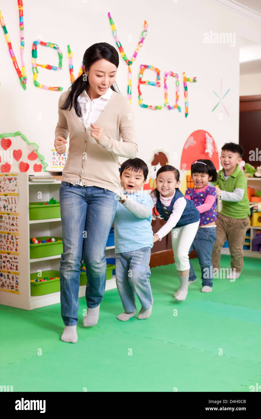 Happy kindergarten children and teacher playing games Stock Photo Alamy