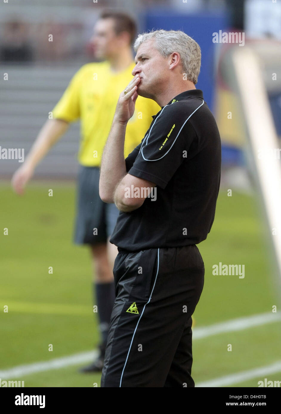 Coach of Manchester City, Mark Hughes, watches his team's test match
