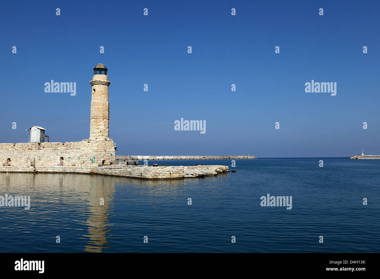 The Venetian era harbour walls and lighthouse at the Mediterranean port of Rethymnon, Crete, Greek Islands, Greece Stock Photo