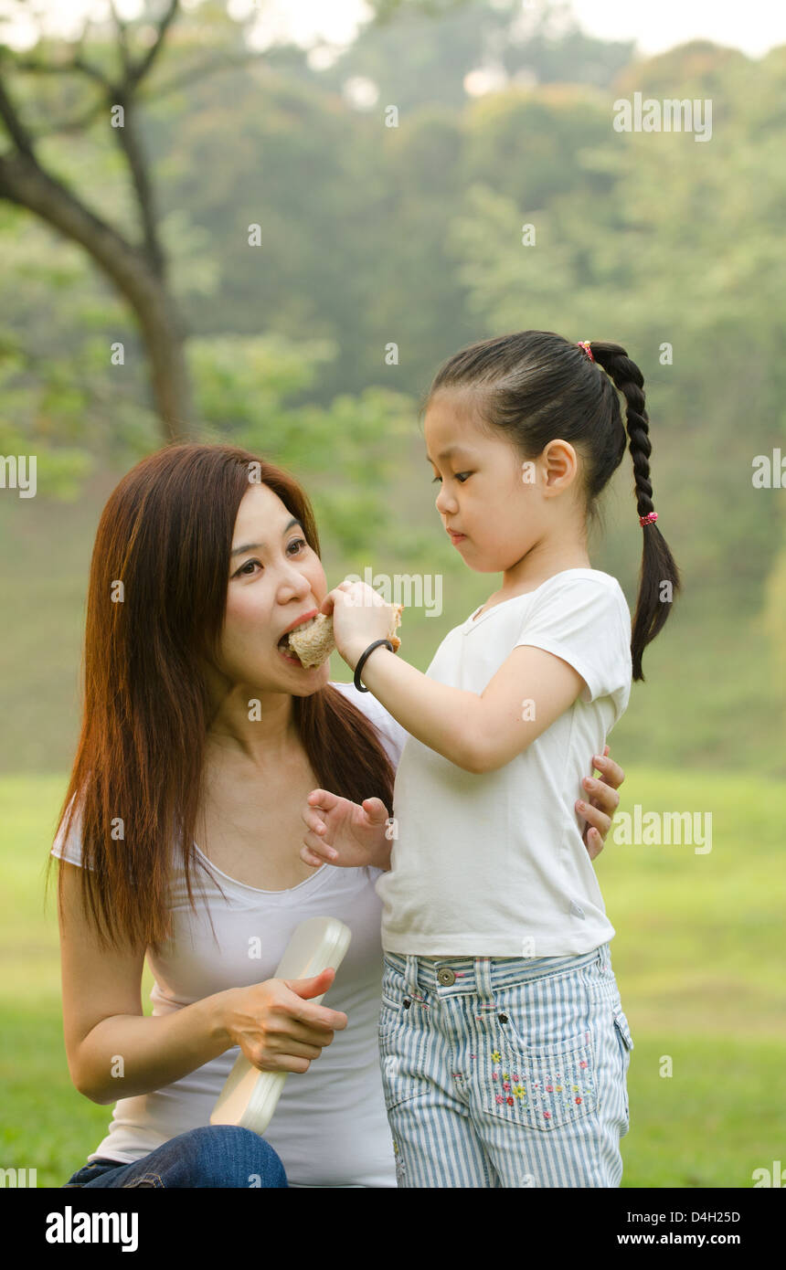 asian chinese girl feeding her mother in outdoor green park Stock Photo ...