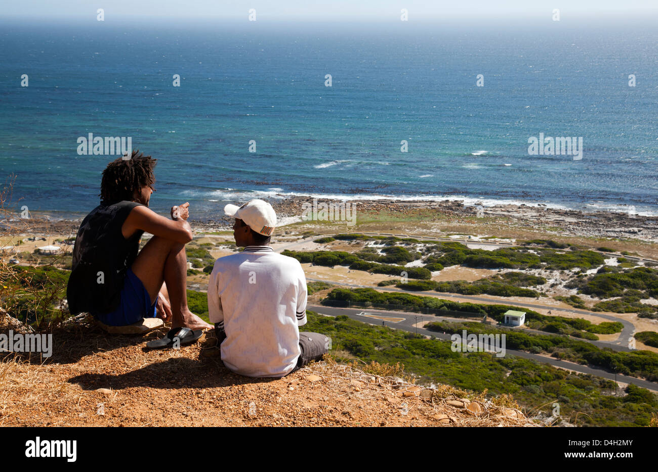 Two Local guys Sitting on Roadside edge at Slangkop - western Cape - South Africa Stock Photo