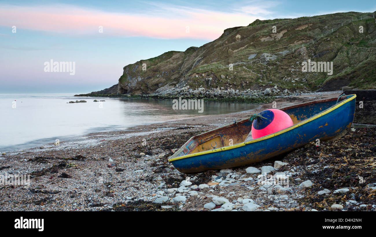 Blue boat at Lulworth Cove on Dorset's Jurassic Coast Stock Photo