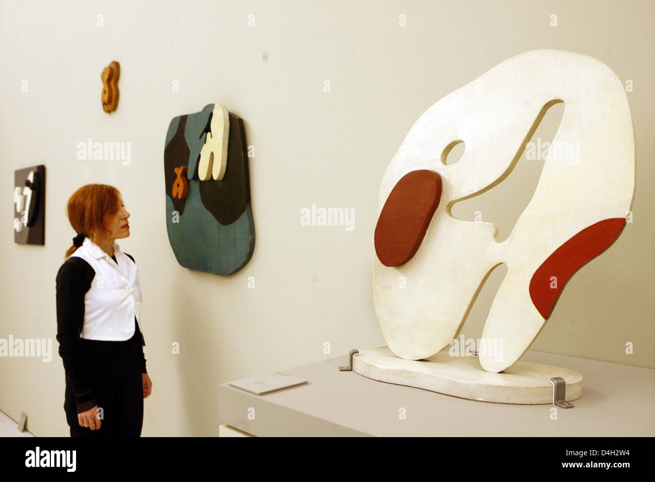 An employee of Strasbourg's 'Musee d'art moderne et temporaire' museum observes the sculpture 'Kopf-Stabile' (1926/ foreground) (literally: Head-Stable) by French artist Jean Hans Arp at the museum's Arp-Exhibition in Strasbourg, France, 15 October 2008. On the occasion of its 10th anniversary, the museum of modern and contemporary arts dedicates an exhibiton to Jean Hans Arp, who  Stock Photo