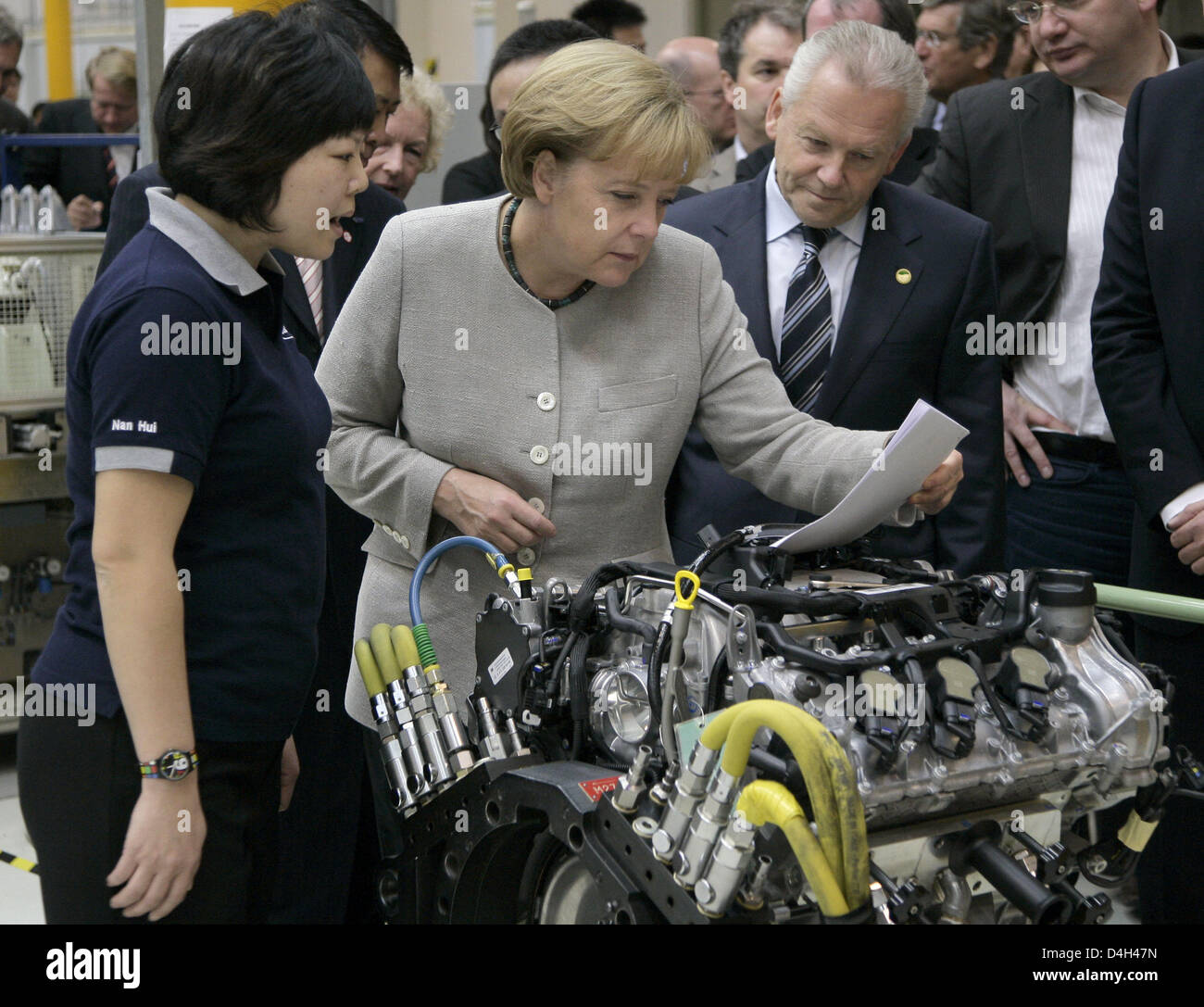 German Chancellor Angela Merkel stands next to Ruediger Grube (3-L), bord member of Daimler AG, during her visit at the Mercedes-Benz factory when vehicle no. 25,000 is being produced in Beijing, China, 23 October 2008. Merkel will hold bilateral talks and attend the Asia-Europe Meeting (ASEM) during her three-day stay at the chinese capital. Photo: Peer Grimm Stock Photo
