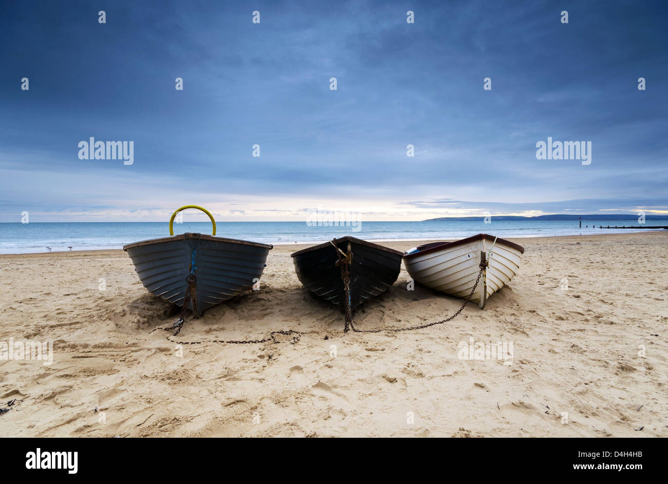 Fishing boats under a brooding sky at Durley Chine on Bournemouth beach. Stock Photo