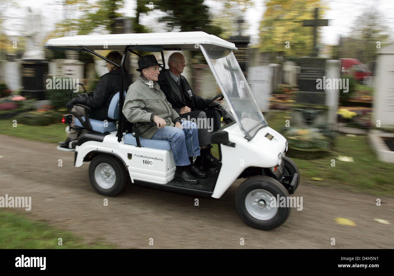 An employee drives an elderly man with the cemetery vehicle at the northern cemetery in Munich, Germany, 19 October 2008. The four-seat electronic vehicle will allow visitors to select a grave without having to walk long distances. Photo: ANDREAS GEBERT Stock Photo