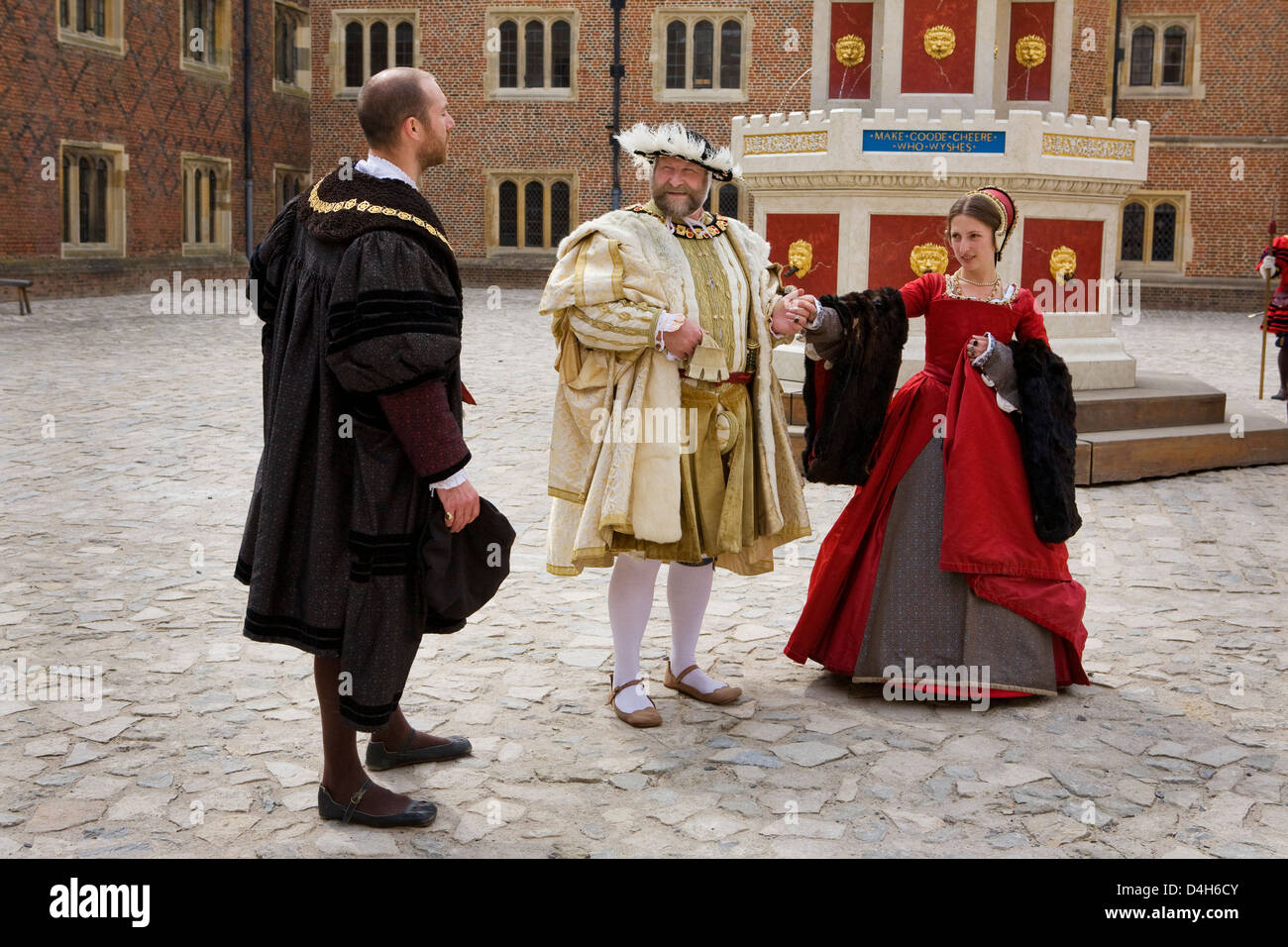 King Henry VIII and Catherine Howard in 1540, portrayed by actors, in the Base Court, Hampton Court Palace, Surrey, England Stock Photo