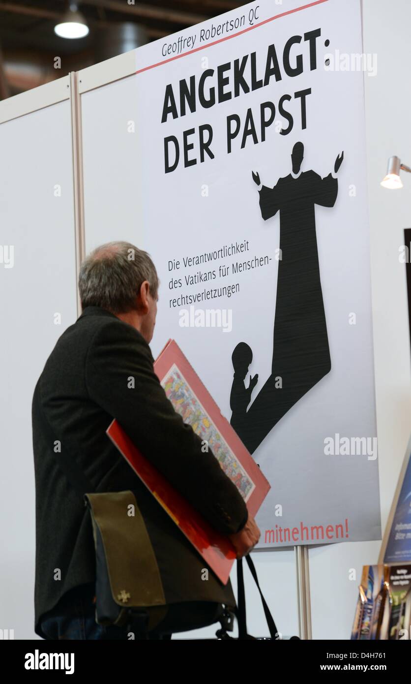 A man looks at a placard advertising Geoffrey Robertson's book  'Angeklagt: Der Papst' (orig. title 'The Case of the Pope: Vatican Accountability for Human Rights Abuse') during the opening of the Leipzig Book Fair in Leipzig, Germany, 14 March 2013. More than 2,000 publishing houses are presented at the fair, which takes place until 17 March. Photo: JENS KALAENE Stock Photo