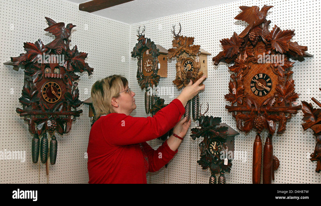 Employee Kathrin Krummhaar arranges cuckoo wall clocks at clock factory