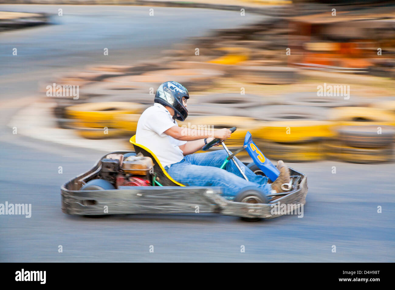 Horizontal take of an Asian driver and go kart as they zoom past on a public race track in Goa India Stock Photo